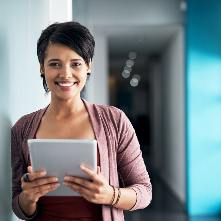 Woman Smiling and Holding Paperwork in Office Space