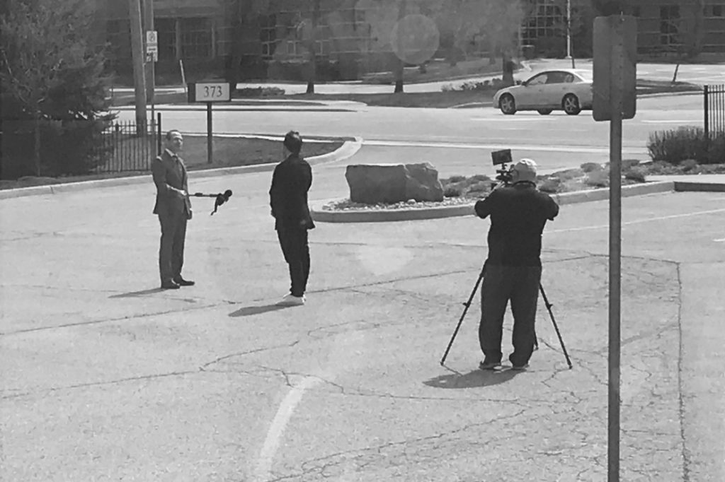Outside Interview Showing Camera filming Interview in Black and White