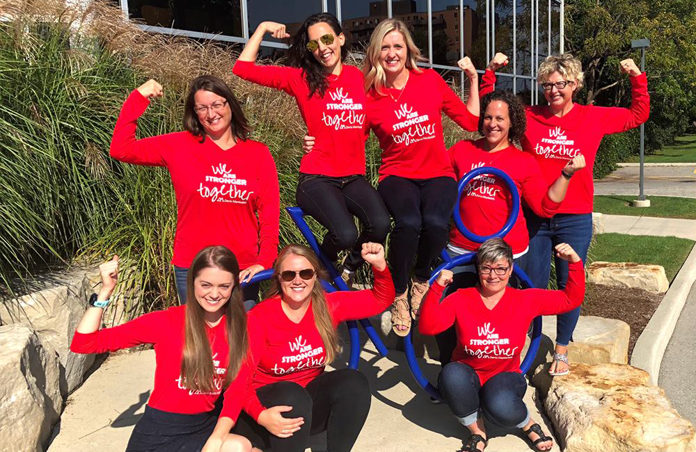 Group of team members together all wearing matching red shirts.